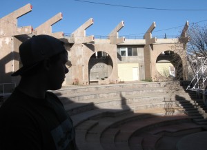 CG surveys the amphitheater, with its perpetually empty storefronts (background circles).
